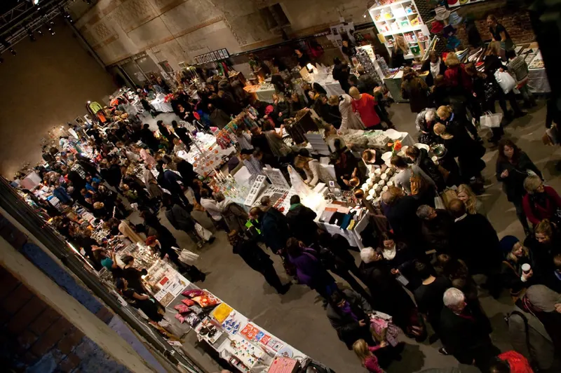 Packed stalls and visitors in the hall at Designernes julemarked.